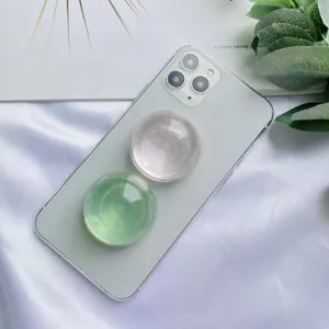 Primo piano di supporti per telefono a sfera di cristallo verdi e iridescenti su smartphone