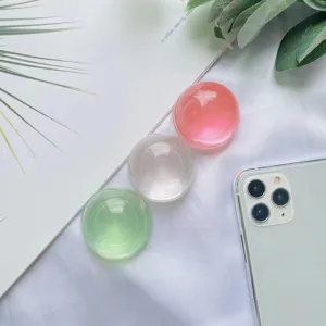 Primo piano di tre impugnature per telefono a sfera di cristallo traslucido in vari colori