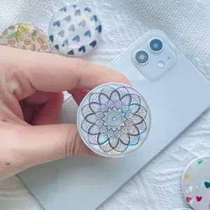 Close-up van een holografische mandala telefoonhouder gehouden voor een blauwe smartphone.