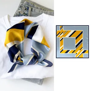 Detailed view of stylish geometric silk square scarf with vibrant yellow and blue color block design.