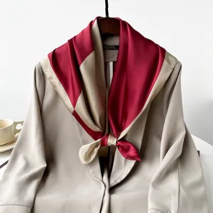 Gros plan sur les details du foulard en soie bicolore presente sur un blazer chic.