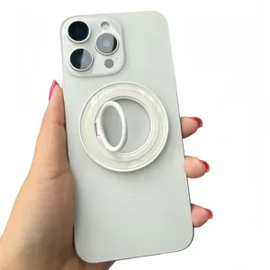 Close-up of a white magnetic phone ring holder with seashell texture on a white phone