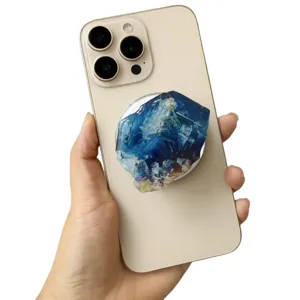 Blue faux crystal acrylic resin magnetic phone grip stand attached to golden smartphone