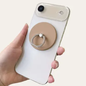 Close-up of beige matte magnetic phone ring holder attached to a white smartphone back