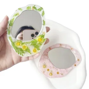 Unregelmäßiger Harz-Hand-Make-up-Spiegel mit echten getrockneten Blumen im floralen Stil.