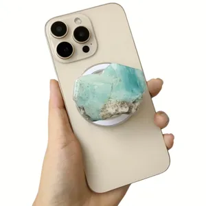 Close-up of blue imitation crystal magnetic phone grip attached to a gold smartphone