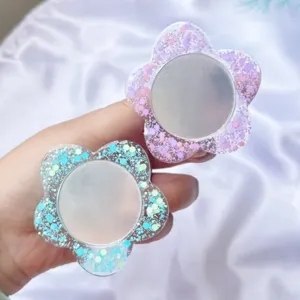 Detailansicht von zwei glitzernden Blumen-Handygriffen mit integrierten Spiegeln.