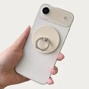 Detail showing magnetic phone ring holder attached to a white smartphone back