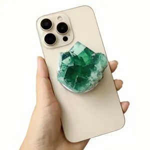 Green faux fluorite crystal magnetic phone grip attached to a sleek cream smartphone