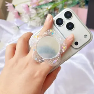 Detailaufnahme eines glitzernden Blumen-Handyhalters aus Acryl mit Schminkspiegel