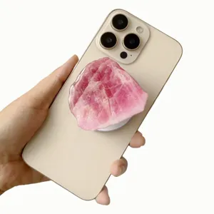Hand holding an iPhone with a decorative pink acrylic crystal magnetic phone grip