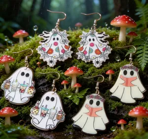 Detailed view of three pairs of cute ghost acrylic earrings in a mossy forest setting.