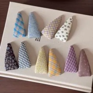 Detailed view of colorful velvet triangular hair clips with plaid and floral patterns
