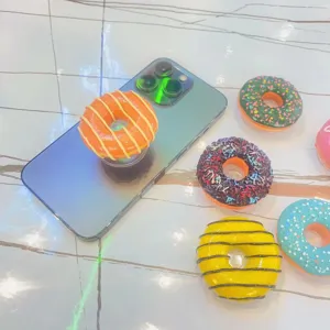 Detaillierte Makroansicht realistischer Donut-Handyhalterungen in bunten Designs.