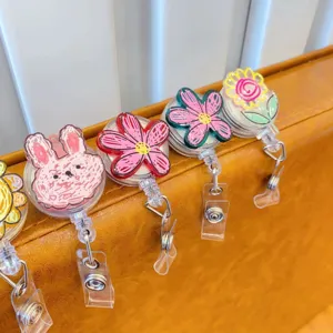 Close-up of cute graffiti cartoon retractable badge reels with floral and bunny designs.