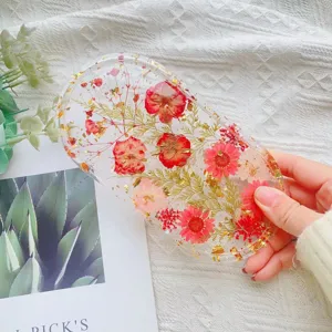 Detailopname van gedroogde roze bloemen en goudfolie in een ovale hars dienblad
