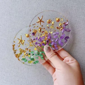 Dettaglio ravvicinato della tavolozza nail art in resina con foglia d'oro e pietre viola