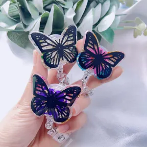 Detailed macro view of three butterfly resin badge reels with gold foil and floral accents