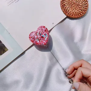 Macro view of a pink glitter heart retractable badge reel holder for nurses and doctors