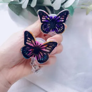 Detailed macro view of butterfly resin badge reel with gold foil and flowers