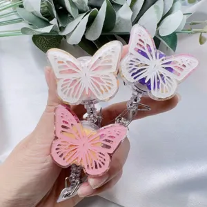 Close-up detail of resin butterfly badge reels with gold foil and pressed flowers