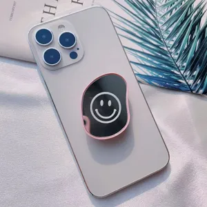 Vista detallada del soporte para móvil ovalado con espejo y diseño de cara feliz