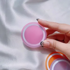 Primer plano de una base de anillo magnético Magsafe rosa macarrón sostenida