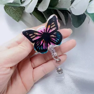 Close-up of a butterfly resin badge reel with gold foil and pink floral details