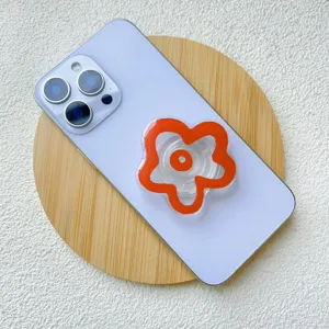 Close-up detail of a vibrant orange acrylic flower phone griptok on a purple smartphone