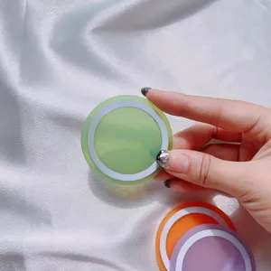 Detalle de una base de anillo magnético MagSafe verde sobre satén blanco