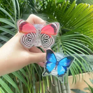 Detail of two acrylic butterfly phone socket grips in vibrant red and dream blue