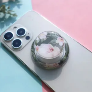 Close-up detail of a decorative floral pattern resin phone grip on a white smartphone