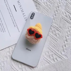 Detailopname van een schattige pluchen telefoonhouder met gele hoed en hartjesbril