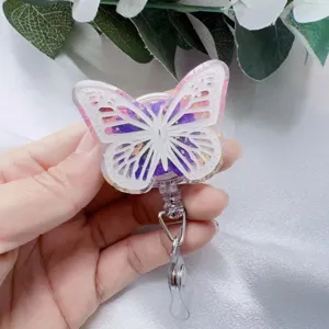 Detail view of a butterfly-shaped retractable badge reel with gold foil and purple accents
