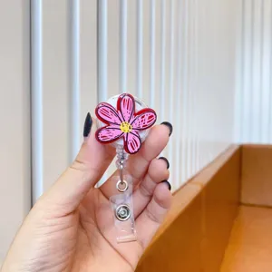 Close-up of cute pink doodle flower retractable badge reel held in hand for nurse id