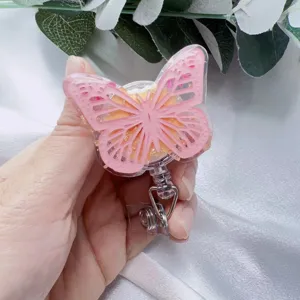 Detailed view of a pink butterfly resin retractable badge reel with gold leaf decoration