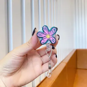 Close-up of cute pink doodle flower retractable badge reel with durable alligator clip