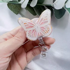 Detailed view of handmade butterfly resin badge reel with real dried flowers and gold foil