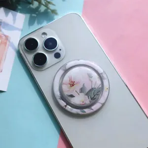 Close-up detail of a stylish circular phone stand featuring a vibrant pink floral pattern