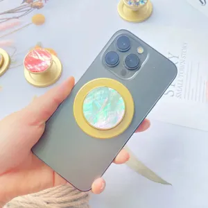 Detailansicht eines irisierenden Perlmutt-Magnet-Handyhalters auf einem grauen Smartphone