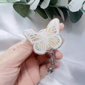 Detailed close-up of a butterfly resin badge reel with elegant gold foil accents