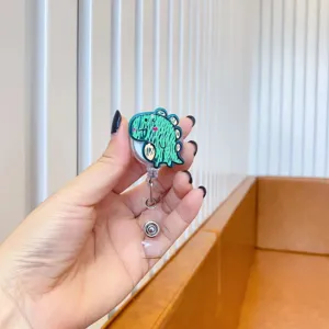 Macro shot of a cute green cartoon dinosaur retractable badge reel for work cards