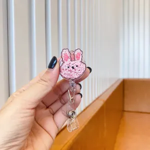 Close-up of a retractable badge reel with a cute pink graffiti-style bunny decoration