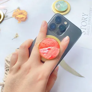 Makrodetail eines magnetischen Handyhalters aus natürlicher Muschel an einem Smartphone