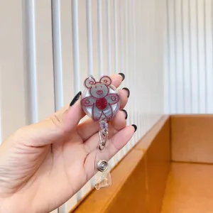 Close-up of a cute red doodle bear retractable badge holder with a clear plastic strap.