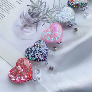 Detailansicht von glitzernden Herz-Ausweisrollen auf einem weißen Stoffhintergrund