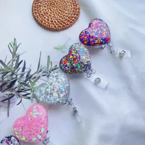 Detail der herzförmigen Ausweishalter mit buntem Glitzer und ausziehbaren Krokodilklemmen