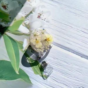 Detail view of a handmade retractable badge reel with real dried flowers in resin.