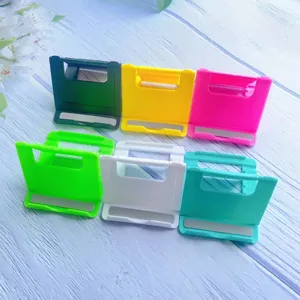 Detailed view of six colorful folding adjustable phone stands arranged on a light blue surface