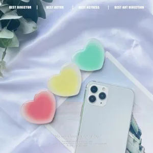 Close-up detail of cute heart-shaped gradient retractable phone grips in pastel colors